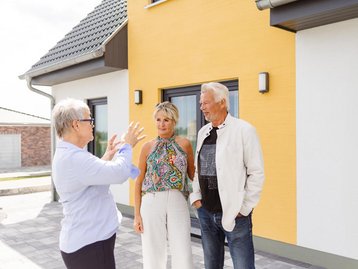 Christel Kohl mit Kunden vor dem Musterhaus in Bad Belzig
