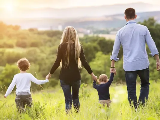 Familie mit zwei Kindern läuft über eine Wiese als Symbol für familienfreundliches Wohnen in Beetzsee