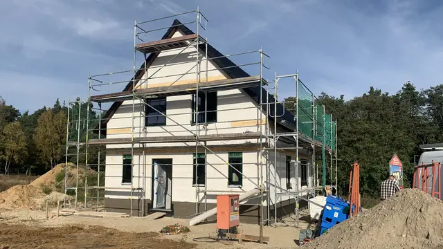 Rohbau eines Massivhauses mit Gerüst auf einer Baustelle als Beispiel für Hausbau in Königs Wusterhausen