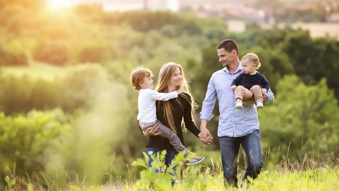 Familienfreundlich wohnen in Beeskow Familie mit zwei Kindern in grüner Landschaft als Symbol für familienfreundliches Wohnen in Königs Wusterhausen