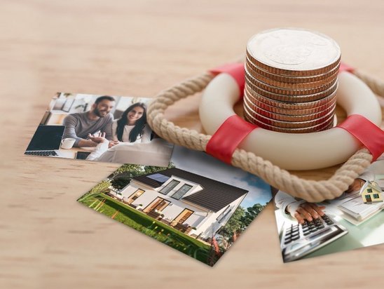 Münzen mit Rettungsring und Hausbildern als Symbol für sichere Baufinanzierung beim Hausbau in Mühlenfließ