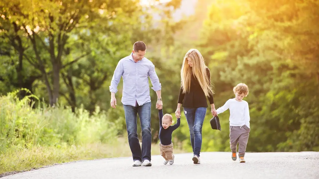 Familie mit zwei Kindern spaziert durch eine grüne Landschaft als Symbol für familienfreundliches Wohnen in Beetzsee